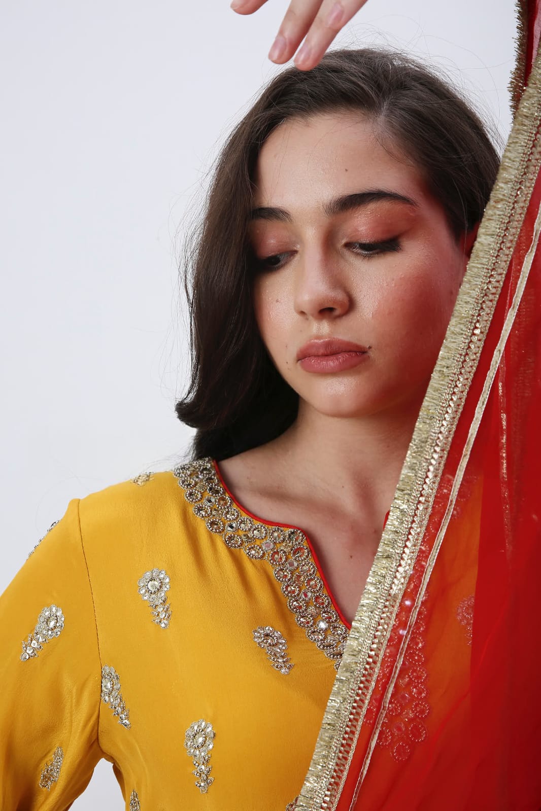 Saffron embroidered kurtaset with red dupatta.