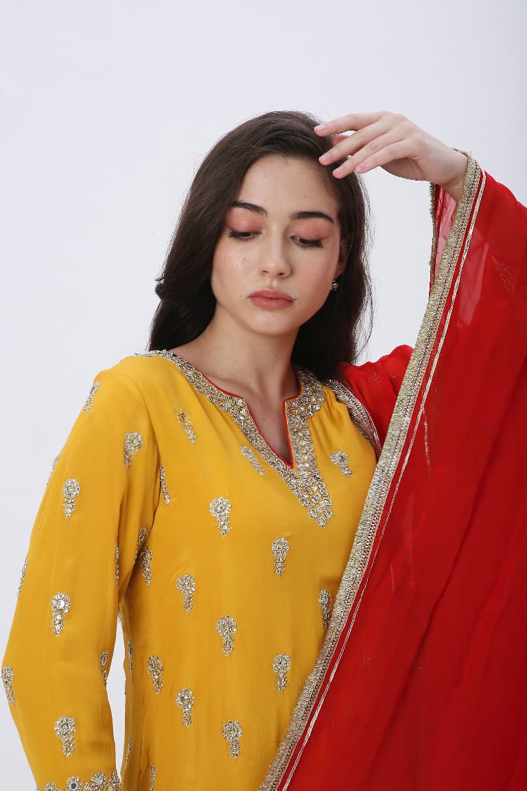 Saffron embroidered kurtaset with red dupatta.