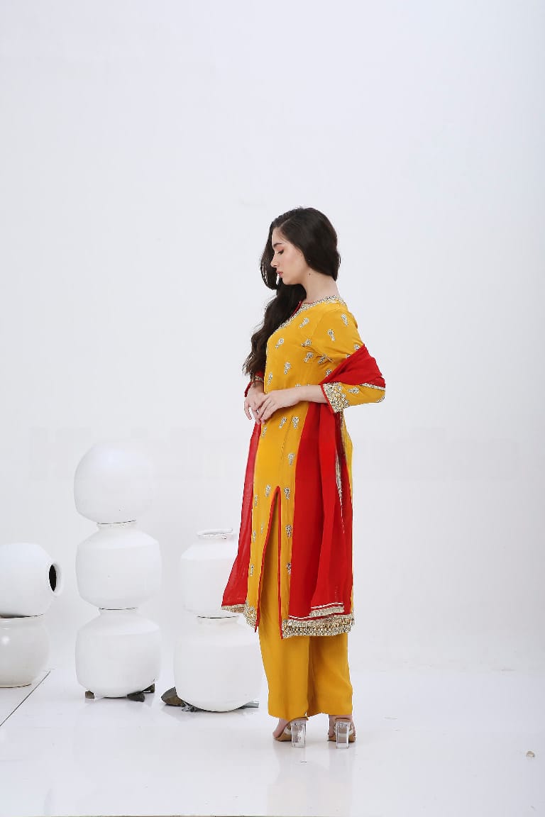 Saffron embroidered kurtaset with red dupatta.